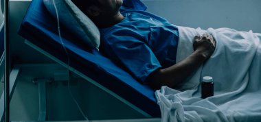 Hastanede koğuşta yatakta Asyalı kadın hasta muayene çeşitli doktorların yan görünümü.