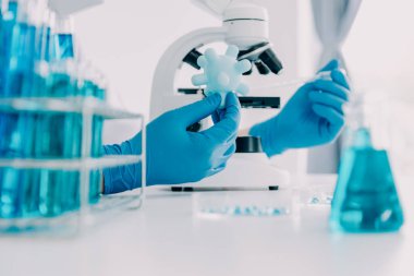 Coronavirus aşısı geliştirmek için mikroskop ile çalışan biyokimyasal araştırma ekibi farmasötik araştırma laboratuvarında, seçici odaklı