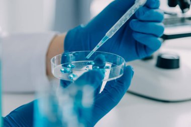 Coronavirus aşısı geliştirmek için mikroskop ile çalışan biyokimyasal araştırma ekibi farmasötik araştırma laboratuvarında, seçici odaklı