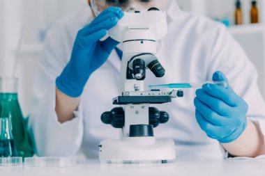 Coronavirus aşısı geliştirmek için mikroskop ile çalışan biyokimyasal araştırma ekibi farmasötik araştırma laboratuvarında, seçici odaklı