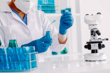 Coronavirus aşısı geliştirmek için mikroskop ile çalışan biyokimyasal araştırma ekibi farmasötik araştırma laboratuvarında, seçici odaklı