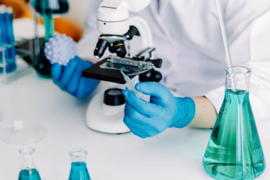 Coronavirus aşısı geliştirmek için mikroskop ile çalışan biyokimyasal araştırma ekibi farmasötik araştırma laboratuvarında, seçici odaklı