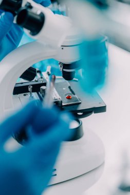 Coronavirus aşısı geliştirmek için mikroskop ile çalışan biyokimyasal araştırma ekibi farmasötik araştırma laboratuvarında, seçici odaklı