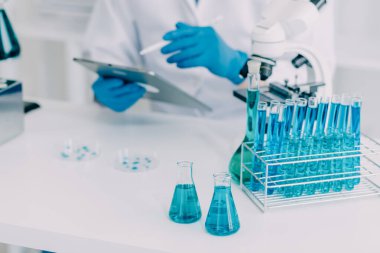 Coronavirus aşısı geliştirmek için mikroskop ile çalışan biyokimyasal araştırma ekibi farmasötik araştırma laboratuvarında, seçici odaklı