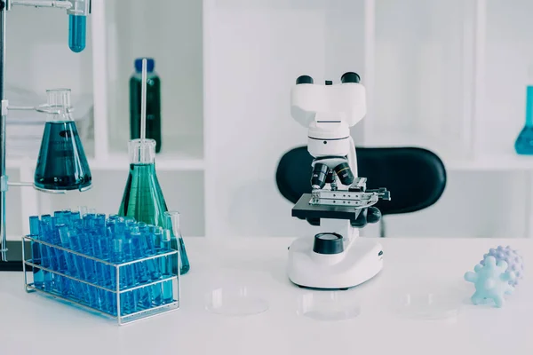 biochemical research scientist team working with microscope for coronavirus vaccine development in pharmaceutical research labolatory, selective focus