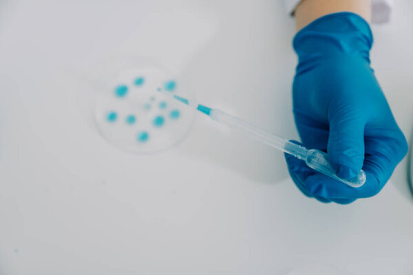 biochemical research scientist team working with microscope for coronavirus vaccine development in pharmaceutical research labolatory, selective focus