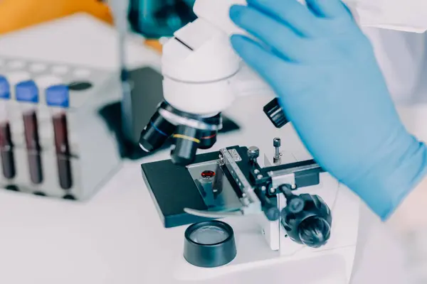 biochemical research scientist team working with microscope for coronavirus vaccine development in pharmaceutical research labolatory, selective focus