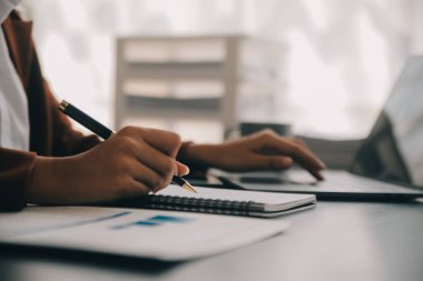 Çekici gülümseyen Asyalı iş kadını ev ofisinde çalışıyor, Asyalı kadın dizüstü bilgisayarında tablet tutuyor..
