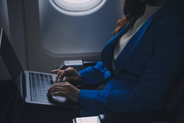 Cep telefonu ve dizüstü bilgisayar kullanan düşünceli Asyalı kadın yolcu gemisi, uçak penceresi tatil seyahatinin heyecanını ve heyecanını mükemmel bir şekilde yakalıyor. Çinliler, Japonlar..