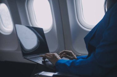 Cep telefonu ve dizüstü bilgisayar kullanan düşünceli Asyalı kadın yolcu gemisi, uçak penceresi tatil seyahatinin heyecanını ve heyecanını mükemmel bir şekilde yakalıyor. Çinliler, Japonlar..