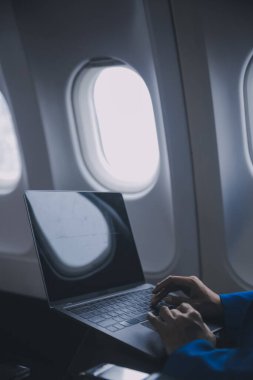 Cep telefonu ve dizüstü bilgisayar kullanan düşünceli Asyalı kadın yolcu gemisi, uçak penceresi tatil seyahatinin heyecanını ve heyecanını mükemmel bir şekilde yakalıyor. Çinliler, Japonlar..