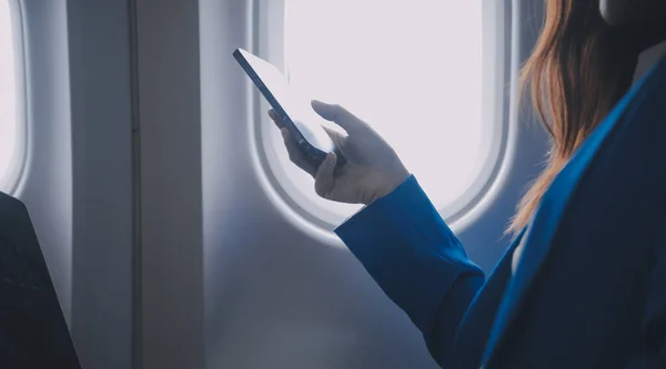 通过使用手机和笔记本电脑 多愁善感的亚洲人 机上女性 飞机窗口 完美地捕捉到了假日旅行的期待和兴奋 中国人 日本人 — 图库照片