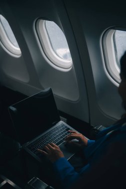 Cep telefonu ve dizüstü bilgisayar kullanan düşünceli Asyalı kadın yolcu gemisi, uçak penceresi tatil seyahatinin heyecanını ve heyecanını mükemmel bir şekilde yakalıyor. Çinliler, Japonlar..