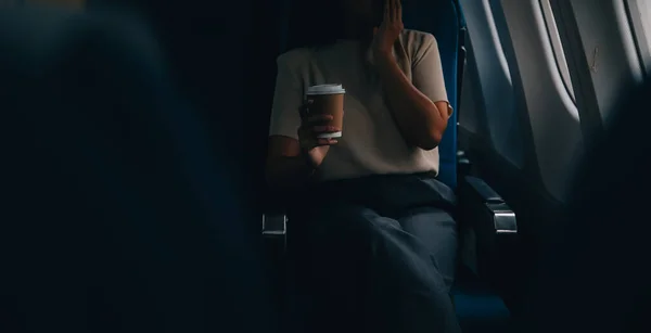 Asyalı Kadın Uçak Kabininde Otururken Rahat Bir Kahvenin Keyfini Çıkarıyor — Stok fotoğraf