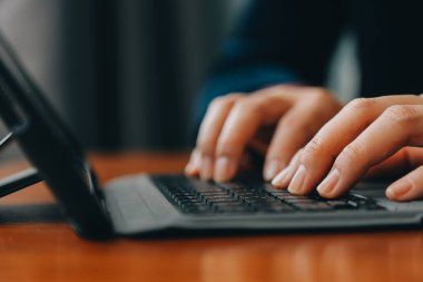 Kurumsal İletişim. Cep telefonuyla konuşan Asyalı iş kadını modern ofiste dizüstü bilgisayarla çalışıyor. Boş Alan