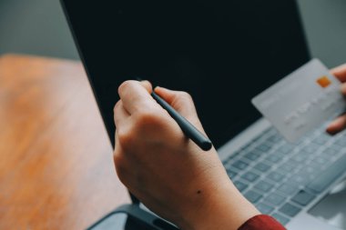 Close up of woman hand using credit card and laptop for payment and online shopping, Online shopping, payments digital banking, E-commerce concept.