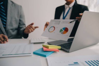 Finansal analistler, şirketlerin başarılı takım çalışmalarının sonuçlarını gösteren bir toplantıda bir dijital tablet planlama yatırım projesinin ticari mali raporlarını analiz ediyorlar..