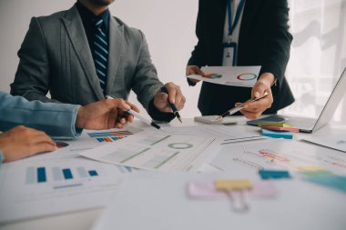 Finansal analistler, şirketlerin başarılı takım çalışmalarının sonuçlarını gösteren bir toplantıda bir dijital tablet planlama yatırım projesinin ticari mali raporlarını analiz ediyorlar..