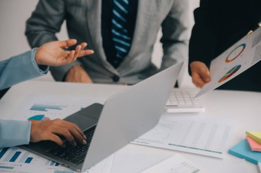 Finansal analistler, şirketlerin başarılı takım çalışmalarının sonuçlarını gösteren bir toplantıda bir dijital tablet planlama yatırım projesinin ticari mali raporlarını analiz ediyorlar..