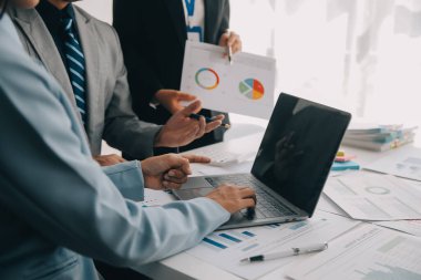 Finansal analistler, şirketlerin başarılı takım çalışmalarının sonuçlarını gösteren bir toplantıda bir dijital tablet planlama yatırım projesinin ticari mali raporlarını analiz ediyorlar..