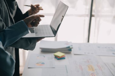 Finansal analistler, şirketlerin başarılı takım çalışmalarının sonuçlarını gösteren bir toplantıda bir dijital tablet planlama yatırım projesinin ticari mali raporlarını analiz ediyorlar..