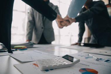 Finansal analistler, şirketlerin başarılı takım çalışmalarının sonuçlarını gösteren bir toplantıda bir dijital tablet planlama yatırım projesinin ticari mali raporlarını analiz ediyorlar..