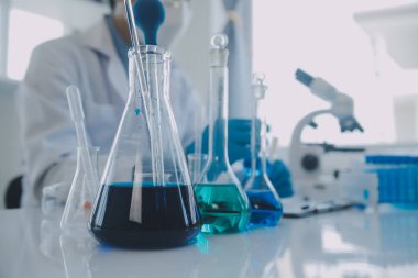 Coronavirus aşısı geliştirmek için mikroskop ile çalışan biyokimyasal araştırma ekibi farmasötik araştırma laboratuvarında, seçici odaklı