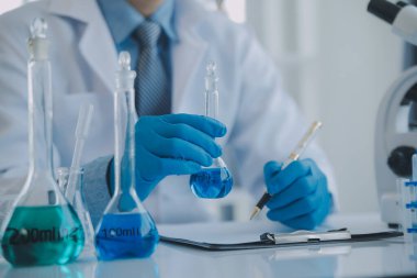 Coronavirus aşısı geliştirmek için mikroskop ile çalışan biyokimyasal araştırma ekibi farmasötik araştırma laboratuvarında, seçici odaklı