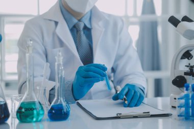 Coronavirus aşısı geliştirmek için mikroskop ile çalışan biyokimyasal araştırma ekibi farmasötik araştırma laboratuvarında, seçici odaklı