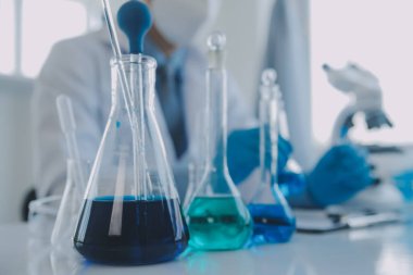 Coronavirus aşısı geliştirmek için mikroskop ile çalışan biyokimyasal araştırma ekibi farmasötik araştırma laboratuvarında, seçici odaklı