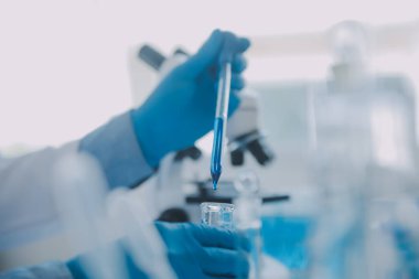 Coronavirus aşısı geliştirmek için mikroskop ile çalışan biyokimyasal araştırma ekibi farmasötik araştırma laboratuvarında, seçici odaklı