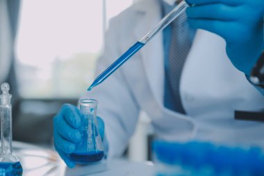 Coronavirus aşısı geliştirmek için mikroskop ile çalışan biyokimyasal araştırma ekibi farmasötik araştırma laboratuvarında, seçici odaklı