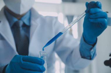 Coronavirus aşısı geliştirmek için mikroskop ile çalışan biyokimyasal araştırma ekibi farmasötik araştırma laboratuvarında, seçici odaklı