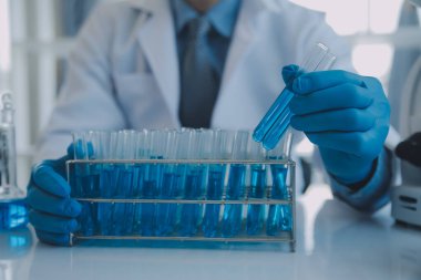 Coronavirus aşısı geliştirmek için mikroskop ile çalışan biyokimyasal araştırma ekibi farmasötik araştırma laboratuvarında, seçici odaklı