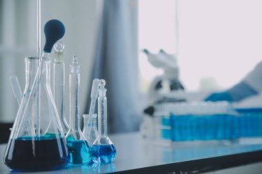 Coronavirus aşısı geliştirmek için mikroskop ile çalışan biyokimyasal araştırma ekibi farmasötik araştırma laboratuvarında, seçici odaklı