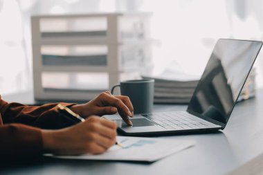 Genç Asyalı kadın portresi modern ofiste bilgisayar tableti üzerinde çalışıyor. Muhasebe analizi yapmak gayrimenkul yatırım verileri, mali ve vergi sistemleri kavramı.