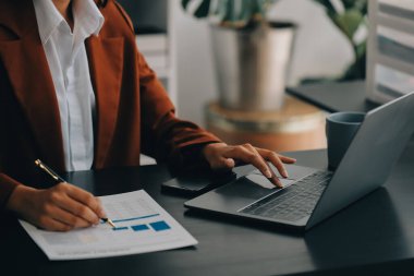 Genç Asyalı kadın portresi modern ofiste bilgisayar tableti üzerinde çalışıyor. Muhasebe analizi yapmak gayrimenkul yatırım verileri, mali ve vergi sistemleri kavramı.