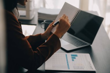 Genç Asyalı kadın portresi modern ofiste bilgisayar tableti üzerinde çalışıyor. Muhasebe analizi yapmak gayrimenkul yatırım verileri, mali ve vergi sistemleri kavramı.