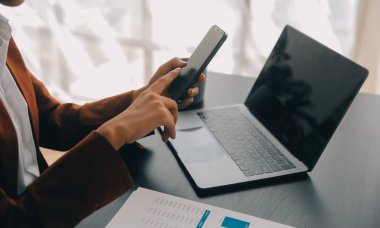 Bir ofis masası, vergi, rapor, muhasebe, istatistik ve analitik araştırma kavramında matematik finansmanı için hesap makinesi ve dizüstü bilgisayar kullanan Asyalı İş kadını