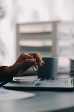 Bir ofis masası, vergi, rapor, muhasebe, istatistik ve analitik araştırma kavramında matematik finansmanı için hesap makinesi ve dizüstü bilgisayar kullanan Asyalı İş kadını