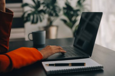 Bir ofis masası, vergi, rapor, muhasebe, istatistik ve analitik araştırma kavramında matematik finansmanı için hesap makinesi ve dizüstü bilgisayar kullanan Asyalı İş kadını