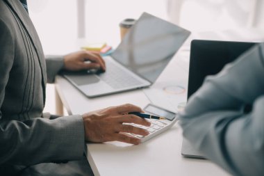 Finansal analistler, şirketlerin başarılı takım çalışmalarının sonuçlarını gösteren bir toplantıda bir dijital tablet planlama yatırım projesinin ticari mali raporlarını analiz ediyorlar..