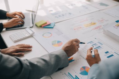 Finansal analistler, şirketlerin başarılı takım çalışmalarının sonuçlarını gösteren bir toplantıda bir dijital tablet planlama yatırım projesinin ticari mali raporlarını analiz ediyorlar..