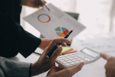 Finansal analistler, şirketlerin başarılı takım çalışmalarının sonuçlarını gösteren bir toplantıda bir dijital tablet planlama yatırım projesinin ticari mali raporlarını analiz ediyorlar..