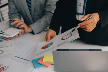 Finansal analistler, şirketlerin başarılı takım çalışmalarının sonuçlarını gösteren bir toplantıda bir dijital tablet planlama yatırım projesinin ticari mali raporlarını analiz ediyorlar..