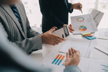 Finansal analistler, şirketlerin başarılı takım çalışmalarının sonuçlarını gösteren bir toplantıda bir dijital tablet planlama yatırım projesinin ticari mali raporlarını analiz ediyorlar..