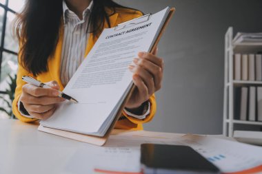 Emlakçı müşterilere örnek evler, ipotekli kredi sözleşmeleri veriyor. Kiralık bir ev alıp satmak için bir sözleşme yap. ve ev sigortası sözleşmeleri, ev kredisi konseptleri