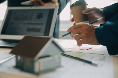 Finansal analistler, şirketlerin başarılı takım çalışmalarının sonuçlarını gösteren bir toplantıda bir dijital tablet planlama yatırım projesinin ticari mali raporlarını analiz ediyorlar..