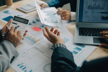 Finansal analistler, şirketlerin başarılı takım çalışmalarının sonuçlarını gösteren bir toplantıda bir dijital tablet planlama yatırım projesinin ticari mali raporlarını analiz ediyorlar..