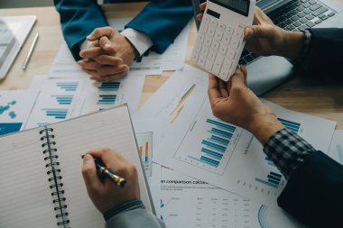 Finansal analistler, şirketlerin başarılı takım çalışmalarının sonuçlarını gösteren bir toplantıda bir dijital tablet planlama yatırım projesinin ticari mali raporlarını analiz ediyorlar..